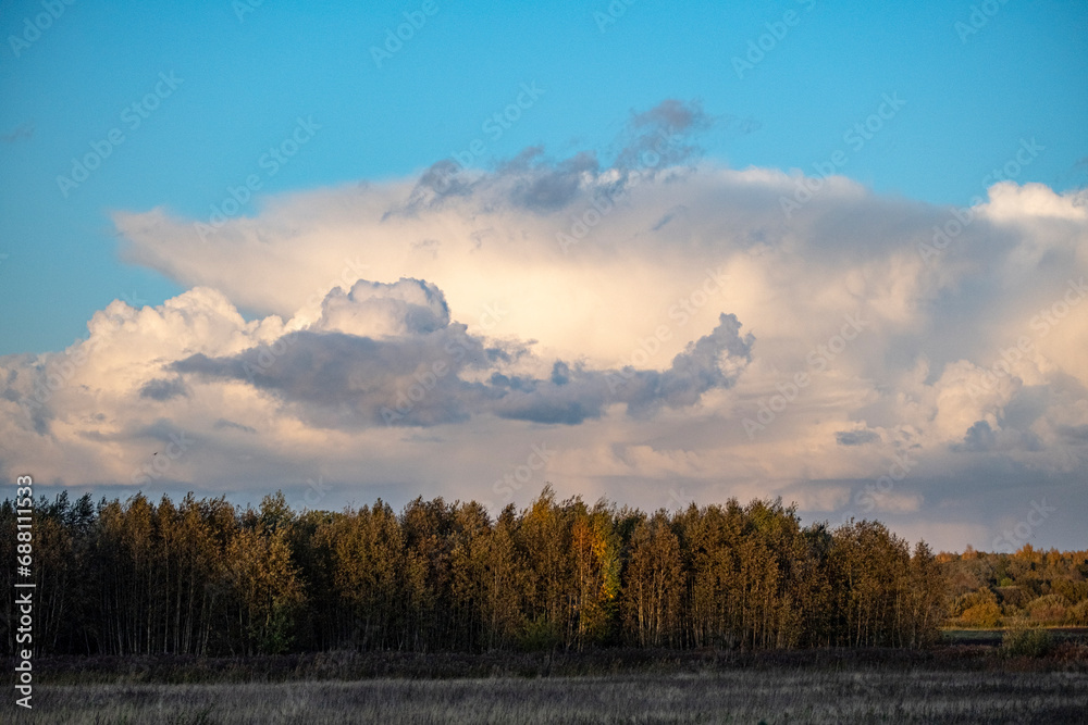 blue autumn sky with beautiful dramatic clouds over field