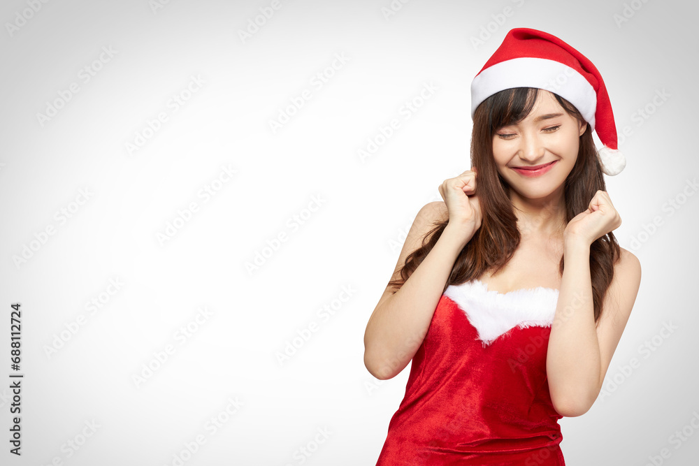 Christmas theme beautiful mixed asian and Caucasian young lady in red Santa costume with Santa hat smiling happily with excitement about celebration or promotion content white and grey background
