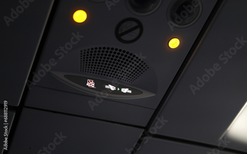 Aviation safety rules. Close up photo with safety light signs inside and airplane like no usage of electronics during take-of, seat belt and no smoking. Travel by plane. photo