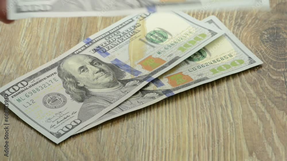 Dollar bills being counted, symbolizing a financial or business theme, with money being added to a wallet. Dollar bills being counted, symbolizing a financial or business theme, with money being added to a wallet.