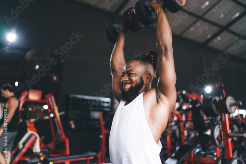 Strong black man lifting dumbbells in gym © BullRun