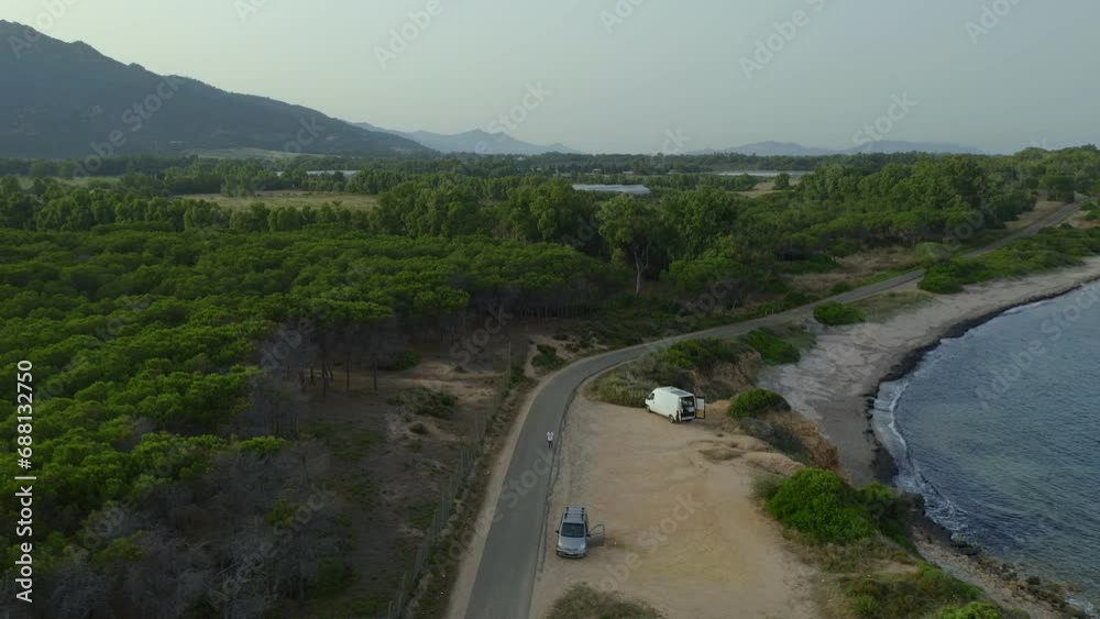 Drone aerial view of a camper van on the south coast of Sardinia and historic tower in Cala dOstia, Italy Drone aerial view of a camper van on the south coast of Sardinia and historic tower in Cala dOstia, Italy