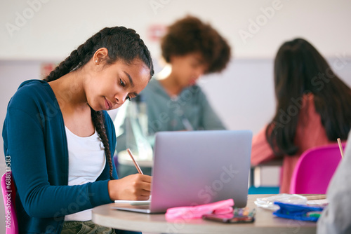 Female Secondary Or High School Pupil With Laptop Working In Study Area 
