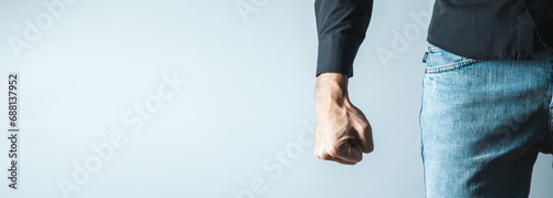 angry man fist on gray wall background