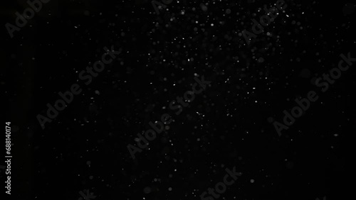 Dust particles on black background. Abstract dust particles with white light bokeh, snow glare and flare sparkles photo