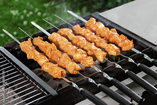 Chicken kebabs on metal skewers fried on a charcoal grill