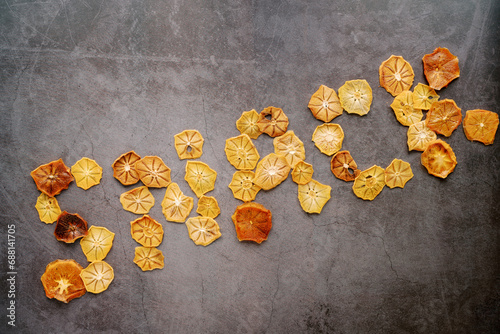 Word snack laid out from fruit chips diagonally on a dark concrete scratched background