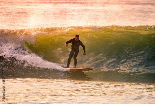 Young Man Riding Wave at Sunset