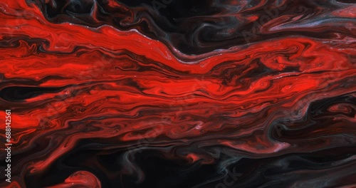 Moving streams of red paint with blue streaks on a dark abstract background, screensaver. The texture of marble. Abstract art. A moving drawing. Liquid abstraction.
