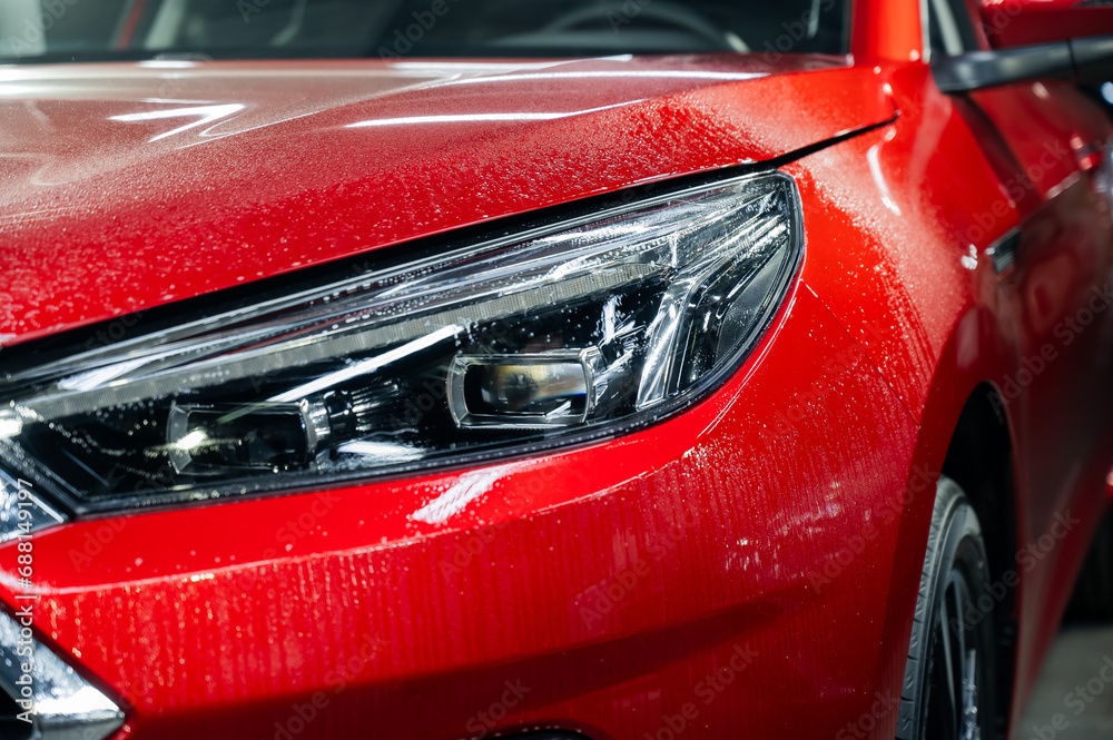 Close-up of a red car headlight with vinyl wrap. 