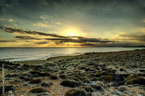 Splendid summer sunset with cloudy sky at rocky Cypriot coast