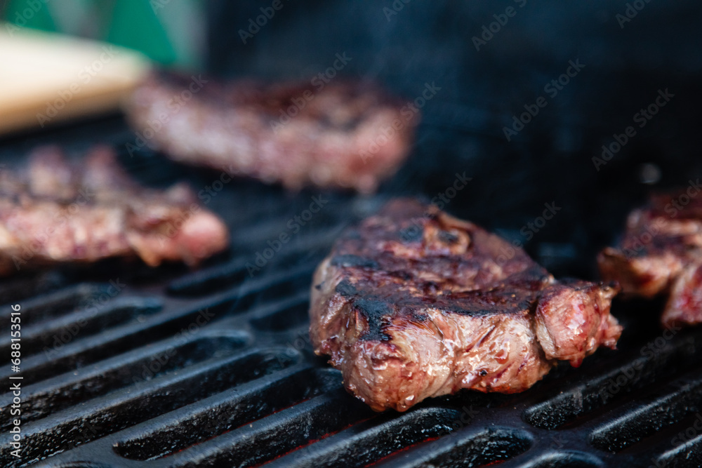 Beef rumpsteak cooked on a cast iron grate on a charcoal grill