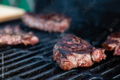 Beef rumpsteak cooked on a cast iron grate on a charcoal grill