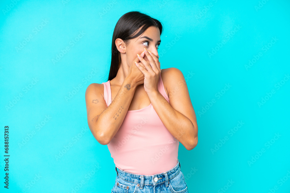 Young caucasian woman isolated on blue background covering mouth and looking to the side Young caucasian woman isolated on blue background covering mouth and looking to the side