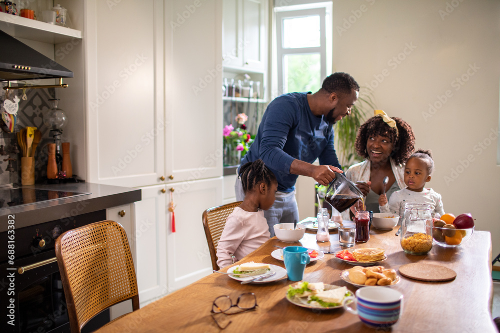 Young family having breakfast together in the kitchen in the morning Young family having breakfast together in the kitchen in the morning