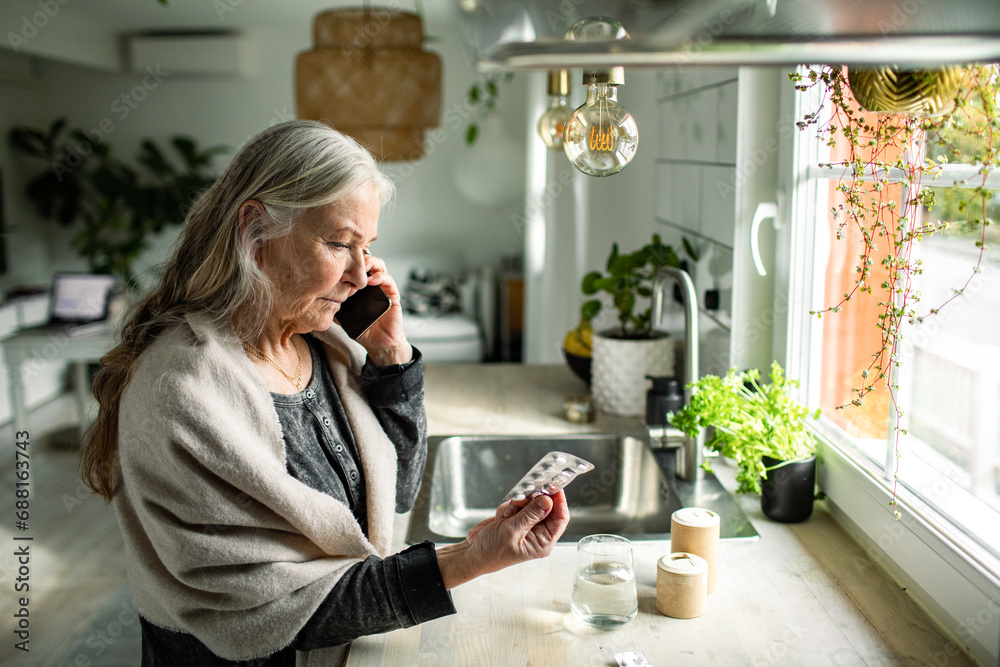 Senior woman calling doctor about medication at home Senior woman calling doctor about medication at home