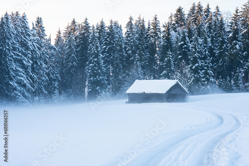 Winter landscape, snow field and barn house