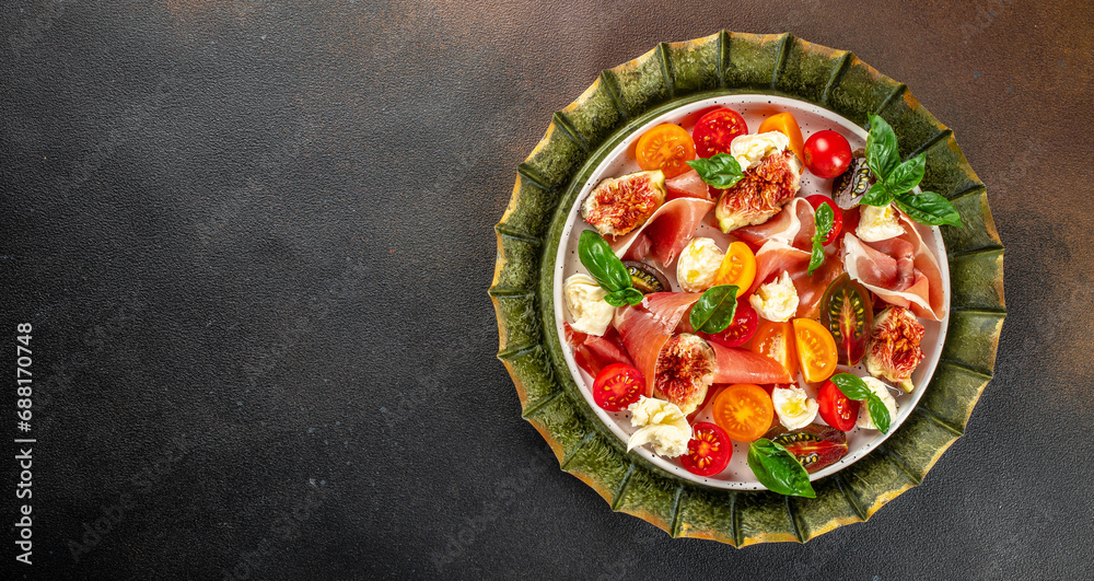 Tomato, figs and mozzarella salad on a dark background. Long banner format. top view - obrazy, fototapety, plakaty 