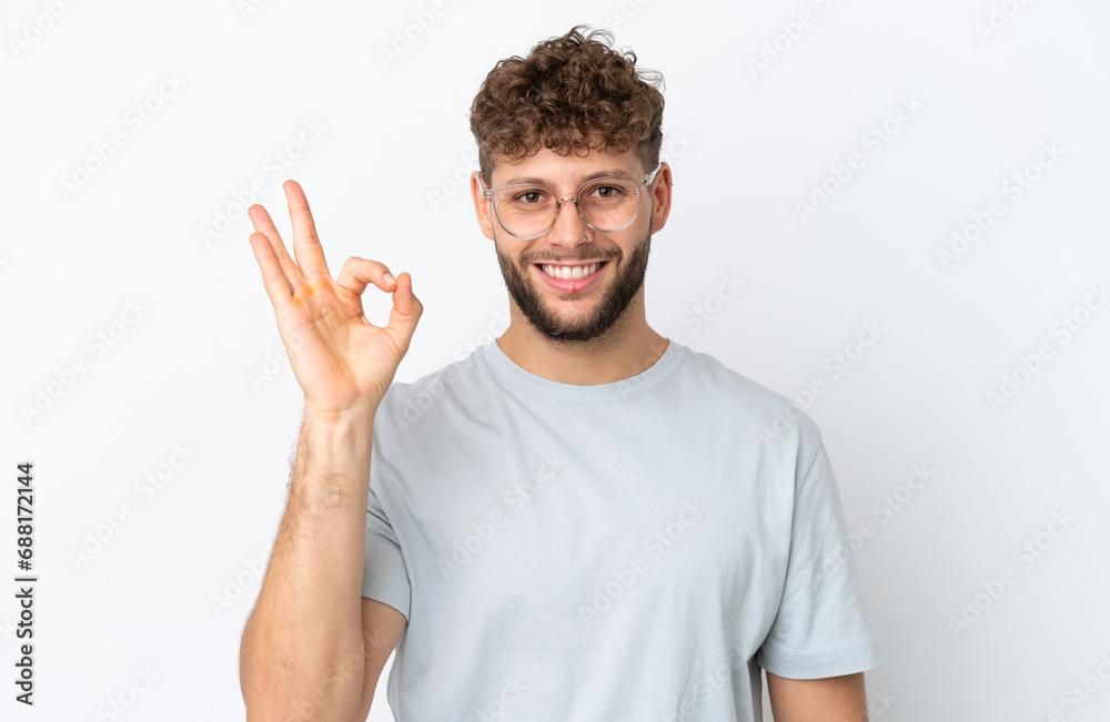 Naklejka premium Young handsome caucasian man isolated on white background With glasses and doing OK sign