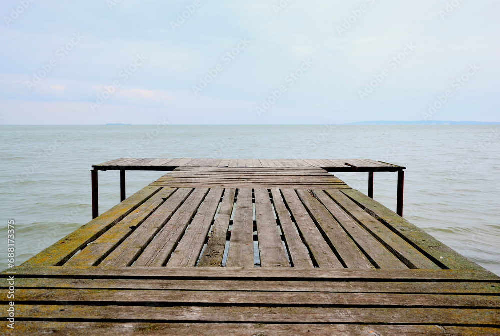 Obraz premium Wooden pier near the water against the blue sky
