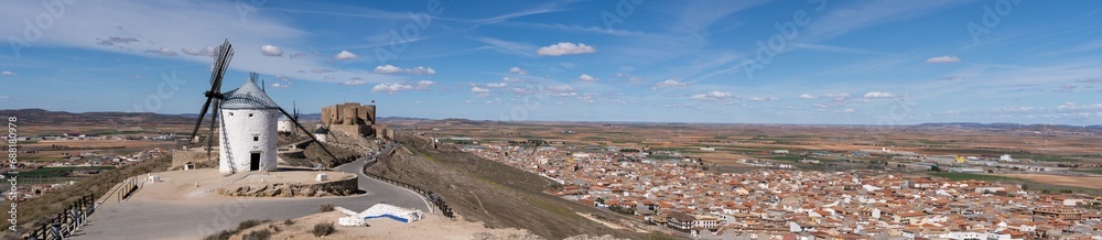 Panoramic view of the old windmills and the Castillo de la Muela located on top of a hill in the town of Consuegra located at the foot of the mountain in the province of Toledo, Spain
