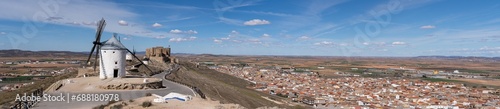 Panoramic view of the old windmills and the Castillo de la Muela located on top of a hill in the town of Consuegra located at the foot of the mountain in the province of Toledo, Spain