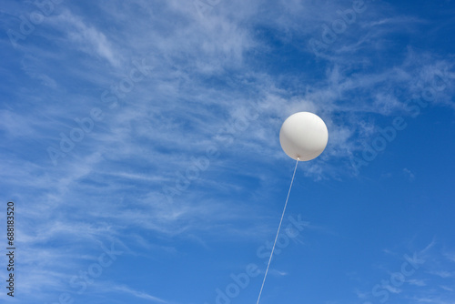 White balloon. A giant inflatable white advertising balloon floats in the sunny blue sky.