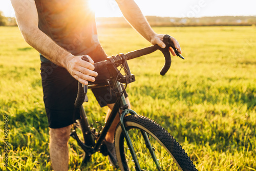 Fototapeta Naklejka Na Ścianę i Meble -  Mountain biker cycling a bike during a sunset outside. Healthy lifestyle and outdoor adventure concept