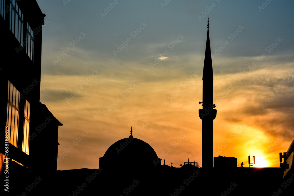 Silhouette of a mosque and the buildings with the sunset background. cityscape sunset town scenery mosque and house silhouettes night city buildings. Golden hour.