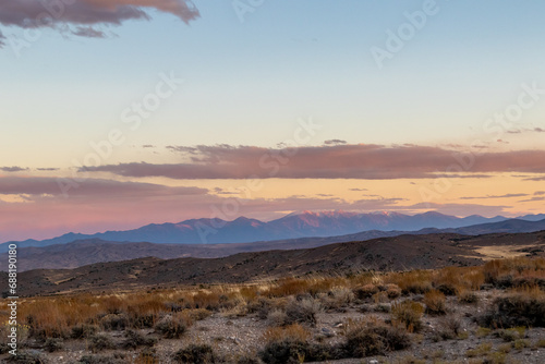 sunset in the desert, image shows the beautiful golden sunset glow in the navada desert with some clouds and a mountain view in the background, taken october 2023 photo