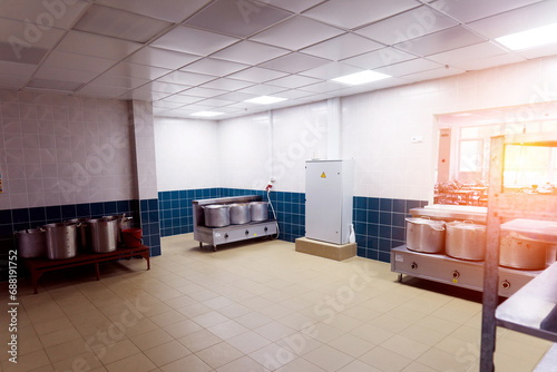 Industrial kitchen in a school restaurant with professional equipment and pans