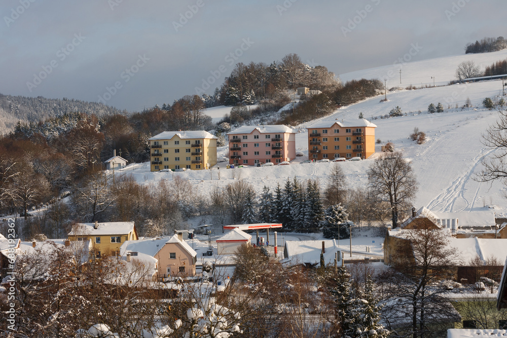 Three apartment buildings on hill in small town, winter morning, after snow falling