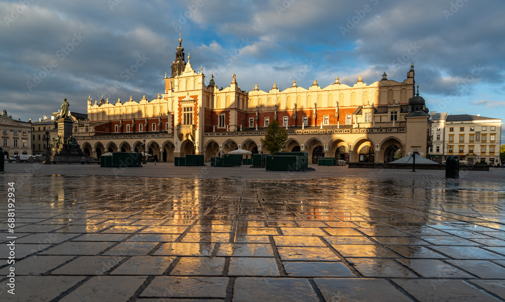 Renaissance Cloth Hall on Krakow Main Square reflecting in the wet cobblestones, sunny morning, Cracow, Poland