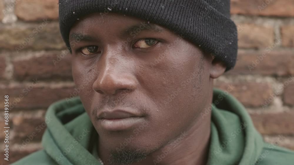 thoughtful proud young black man stares at the camera with serious expression