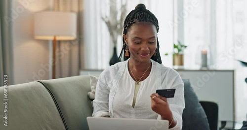 Black woman, credit card and laptop on sofa for online shopping, payment and fintech savings at home. Computer, banking and finance for sales, password and code for financial app, ecommerce or budget photo
