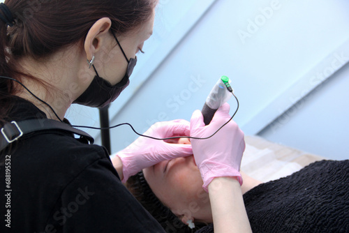 Permanent lip makeup. The cosmetologist makes the procedure of permanent makeup