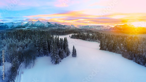 Amazing winter landscape, snow capped mountains and colorful sunset. Aerial view of winter mountain panorama and colorful sky. Tatra mountains and magical unspoiled scenery. 