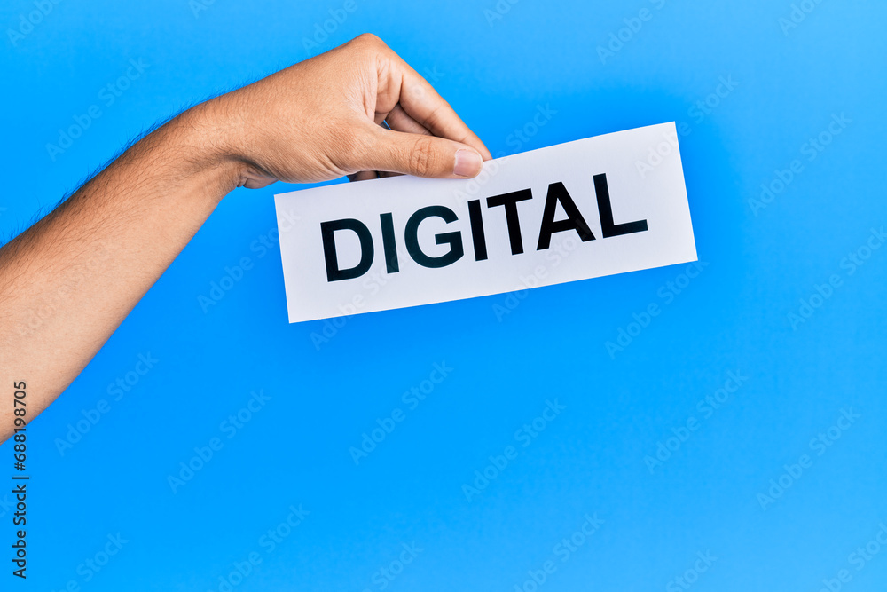 Hand of caucasian man holding paper with digital word over isolated blue background Hand of caucasian man holding paper with digital word over isolated blue background