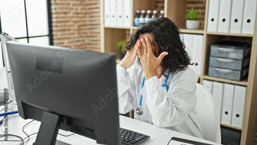 Middle age hispanic woman doctor working stressed at the clinic