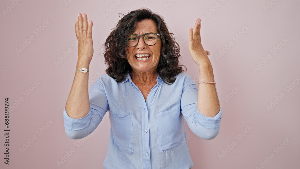 Middle age hispanic woman screaming loudly over isolated pink background Middle age hispanic woman screaming loudly over isolated pink background