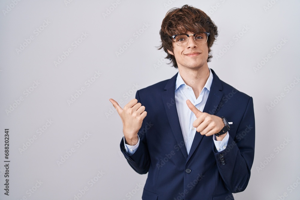 Hispanic business young man wearing glasses pointing to the back behind with hand and thumbs up, smiling confident Hispanic business young man wearing glasses pointing to the back behind with hand and thumbs up, smiling confident