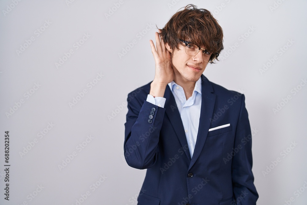 Hispanic business young man wearing glasses trying to hear both hands on ear gesture, curious for gossip. hearing problem, deaf Hispanic business young man wearing glasses trying to hear both hands on ear gesture, curious for gossip. hearing problem, deaf
