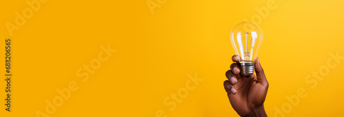 Creative new business solution ideas. Concept for successful invention brainstorm. Copy paste empty place for text. Horizontal banner with African American hand holding a glowing light bulb