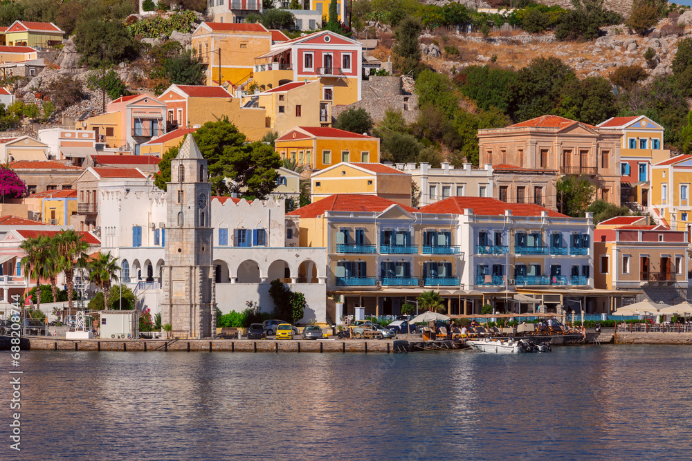 Multi-colored facades of houses in the village Symi on a sunny day.