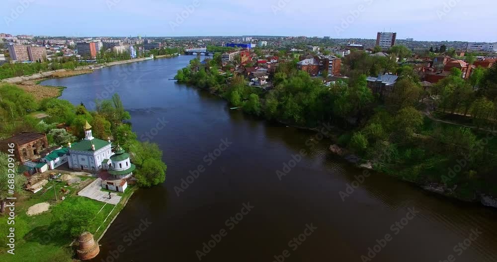 Flying above the river with picturesque banks. Panorama of a beautiful city scattered on the river. Top view. Flying above the river with picturesque banks. Panorama of a beautiful city scattered on the river. Top view.