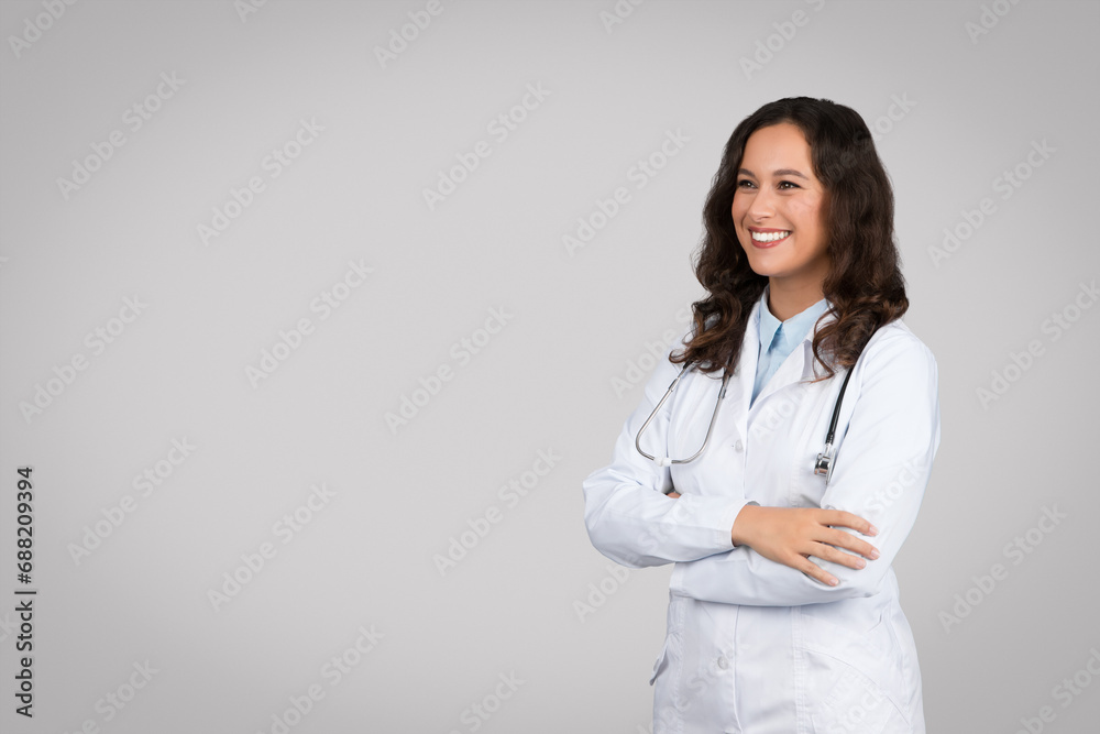 Confident european doctor woman in uniform standing with folded arms looking away at copy space Confident european doctor woman in uniform standing with folded arms looking away at copy space