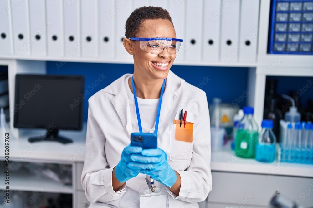 African american woman scientist smiling confident using smartphone at laboratory African american woman scientist smiling confident using smartphone at laboratory