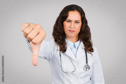 Dissatisfied female doctor giving thumbs down gesture