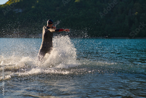 Triathlon athlete starting swimming training on lake © .shock