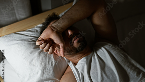 Young arab man lying on bed sleeping at bedroom
